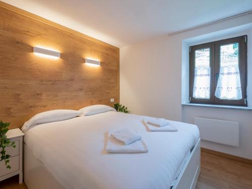 - une chambre avec un grand lit blanc et des serviettes dans l'établissement Luxury apartment in Bormio - Centrale 69, à Piatta