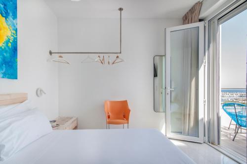 a white bedroom with a bed and a sliding glass door at THE VIEW B&B, terrace & more in San Foca