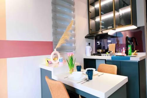 una cocina con una mesa blanca y algunas sillas en NeuSuite Cozy Studio by GUESTONIC, en Kuala Lumpur