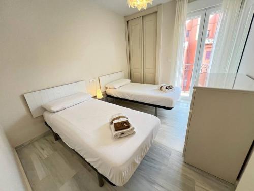 a hotel room with two beds and a window at PUSHE Playa Granada Beach & Golf 17 in Motril