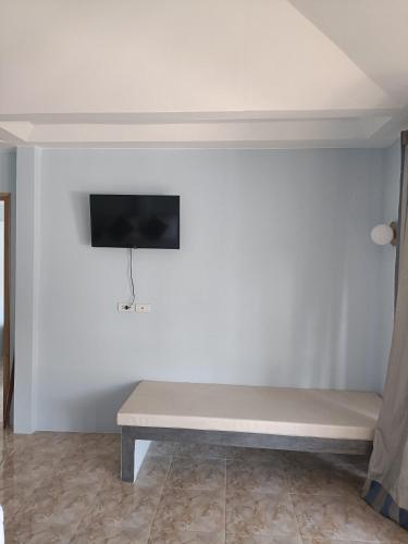 a white wall with a bench in a room at Avocado Koh Samui in Bophut 
