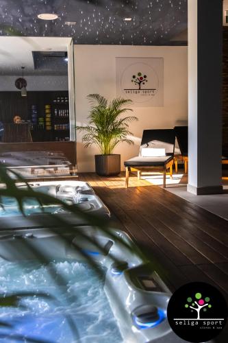 a room with a swimming pool with a couch and a table at Seliga Sport Apartments & SPA in Lesznowola