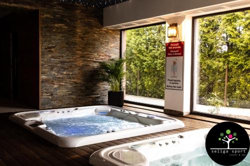 a hot tub in a room with a window at Seliga Sport Apartments & SPA in Lesznowola