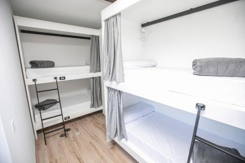 a bedroom with two bunk beds and a desk at Albergue A Fabrica in Santiago de Compostela