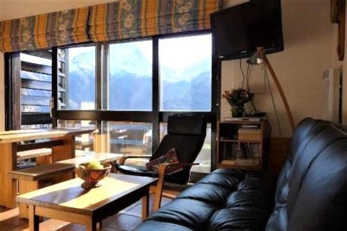 un salon avec un canapé en cuir et une table dans l'établissement CHALET LES SEQUOIAS DEUX ALPES, à Les Deux Alpes