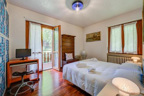 a bedroom with a bed and a tv and a window at Asteria 29 skiing nearby - Happy Rentals in Bardonecchia