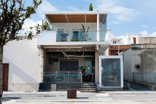 a white house with a glass door at THE VIEW B&B, terrace & more in San Foca
