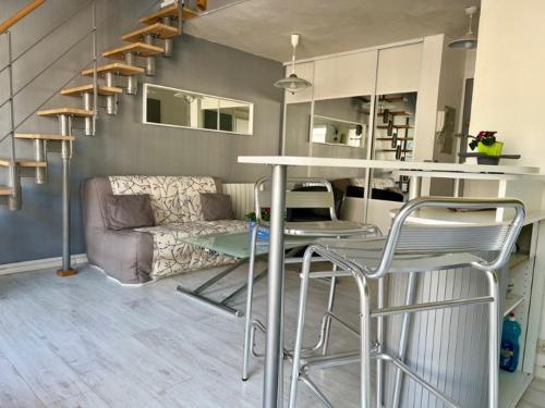 un salon avec une table, des chaises et un canapé dans l'établissement JOLI ET SPACIEUX STUDIO AVEC GARAGE AU BORD DE MER, à Fréjus