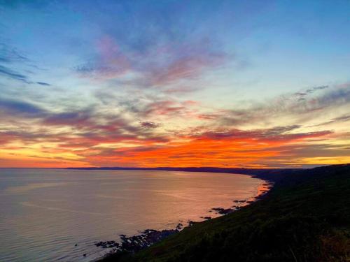 a sunset over a body of water with the sky at Woodleigh in Cawsand