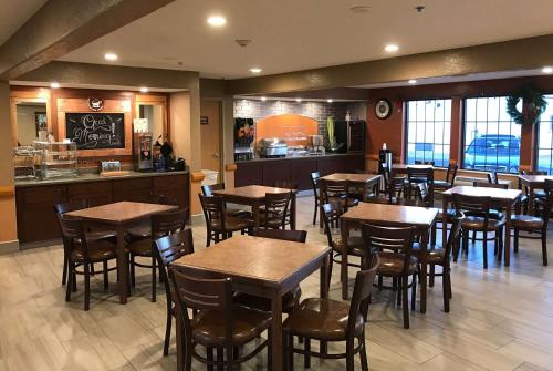 a restaurant with tables and chairs and a kitchen at Americinn by Wyndham Ogallala in Ogallala