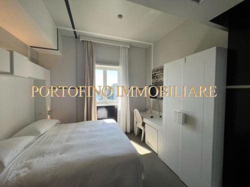 een witte slaapkamer met een bed en een raam bij PORTOFINO SUITE VISTA MARE CON SPIAGGIA PRIVATA in Portofino