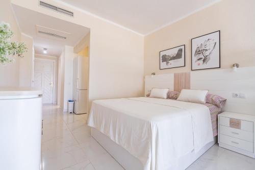 a white bedroom with a large white bed in it at Luxury studio in beachfront complex in El Duque area, Costa Adeje in Adeje