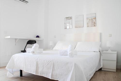 a white bedroom with a white bed with towels on it at Las Estrellas 301 in Torremolinos