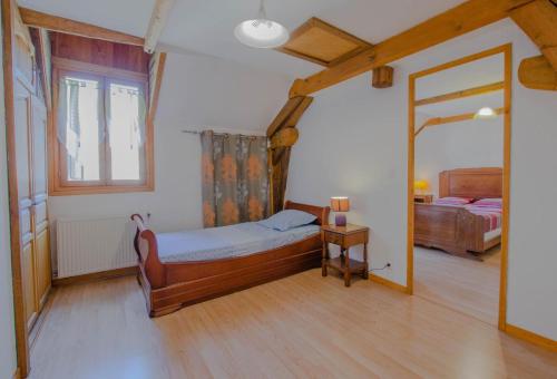 Schlafzimmer mit einem Bett und einem Spiegel in der Unterkunft Au logis des lacs in Piney