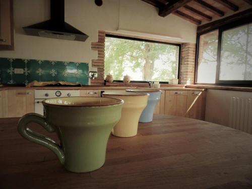 a kitchen with two cups on a wooden table at Borgo Santa Cristina in Castel Giorgio