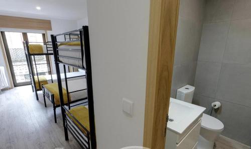 a bathroom with a bunk room with a toilet and a sink at We Are Hostel 2 in Póvoa de Varzim