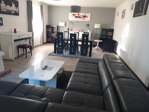 a living room with a leather couch and a table at La maison de vacances 3 chambres in Sausset-les-Pins