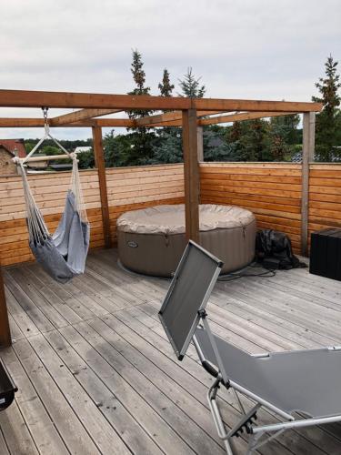 a hammock and a chair on a deck at Apartment am Stettiner Haff in Mönkebude