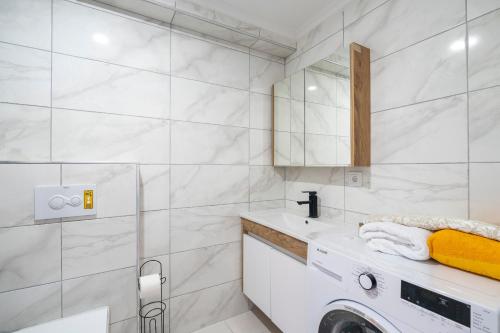 W białej łazience znajduje się pralka. w obiekcie Zeus Suit Görükle w mieście Nilüfer
