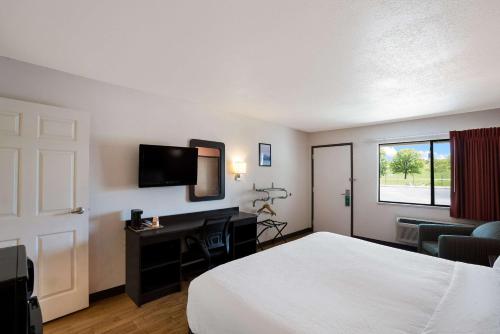 Habitación de hotel con cama, escritorio y TV. en Quality Inn & Suites, en Junction