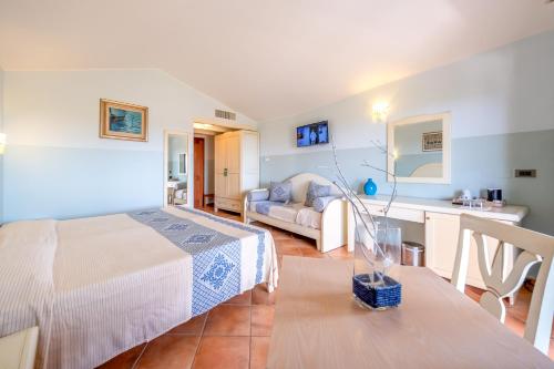 a bedroom with a bed and a couch in a room at Hotel Luci Del Faro in Calasetta