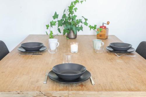 une table en bois avec deux bols noirs et des verres dans l'établissement Appartement Heinrich - Welkeys, à Boulogne-Billancourt
