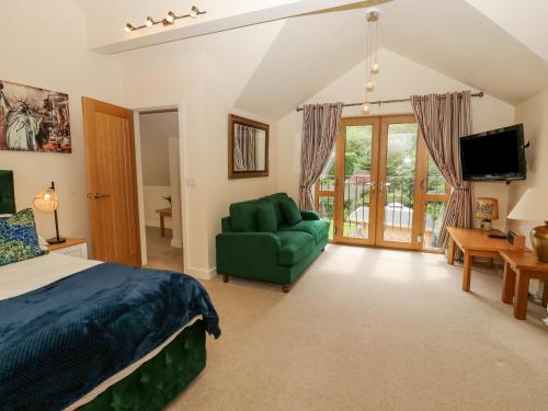 哈德斯菲爾德的住宿－Bradley Manor，一间卧室配有一张床、一张沙发和一台电视