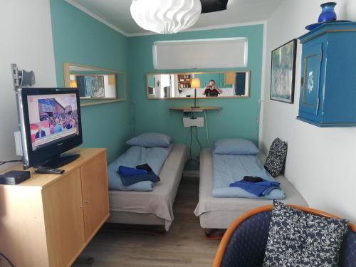 a room with two beds and a flat screen tv at Centrum Aarhus in Aarhus