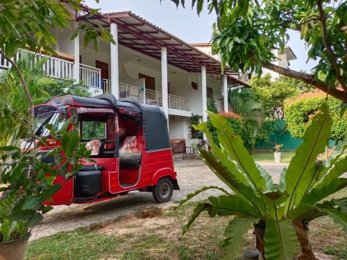 una furgoneta roja estacionada frente a una casa en Weligama Ocean Breeze, en Weligama