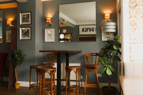 a bar with wooden stools and a mirror at Phoenix Park Hotel in Dublin