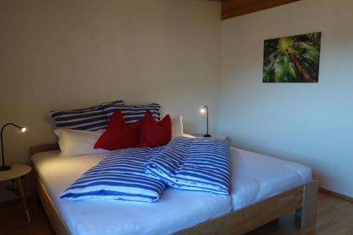un letto con cuscini a righe rosse e blu di Ferienwohnung Mader a Kolsass