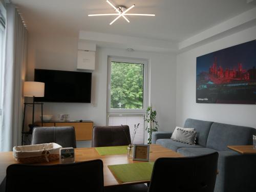 a living room with a table and a blue couch at Vis Saar Vie - Ferienwohnungen an der Saarschleife in Mettlach