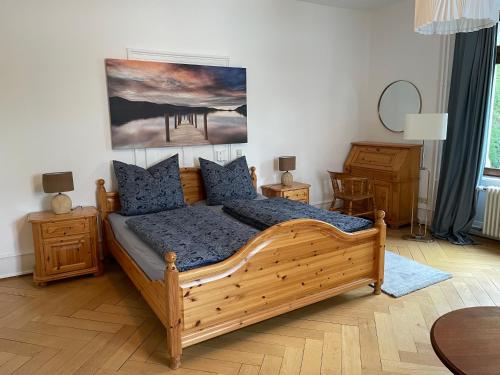 ユーバーリンゲンにあるZum Hölltorのベッドルーム1室(木製ベッド1台、青い枕付)
