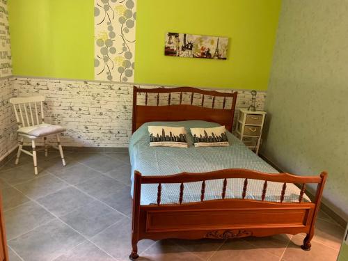a bedroom with a wooden bed and a chair at maison avec jardin et parking privé in Meschers-sur-Gironde