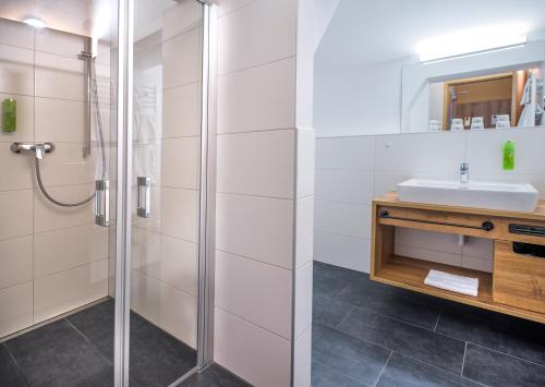 a bathroom with a shower and a sink at JUFA Hotel Altenmarkt-Zauchensee in Altenmarkt im Pongau