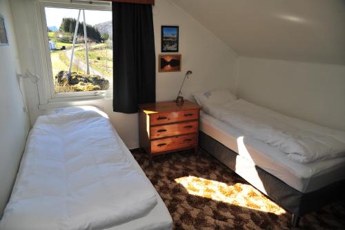 Habitación pequeña con 2 camas y ventana en Fredelig med naturskjønn omgivelse, midt i Lofoten en Jerstad