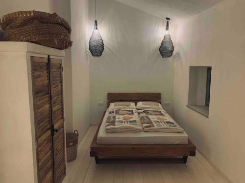 a bedroom with a bed and two pendant lights at Reza house in Branik