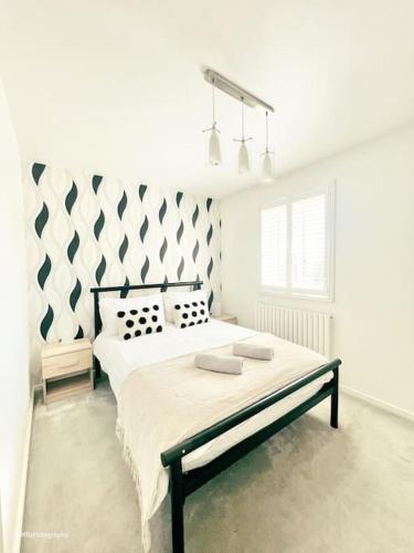 a white bedroom with a bed with two pillows at Modern 3 bed home, Chesterfield in Chesterfield