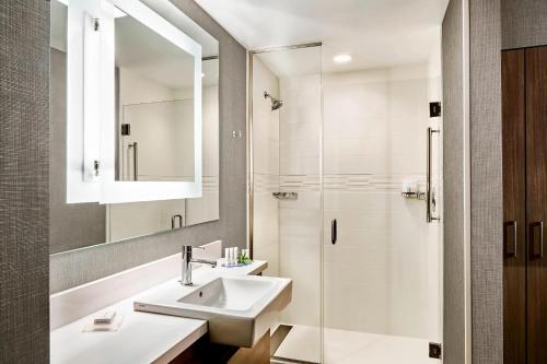 a bathroom with a sink and a shower at SpringHill Suites by Marriott Charlotte Huntersville in Huntersville