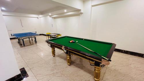 a pool table in a room with two tables at Amahi Inn I Signature Towers in Gurgaon