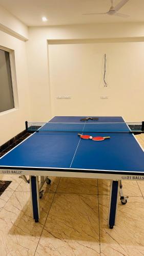 a blue ping pong table with a racket on it at Amahi Inn I Signature Towers in Gurgaon