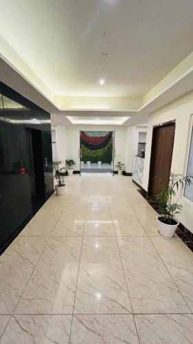 an empty hallway with plants in a building at Amahi Inn I Signature Towers in Gurgaon