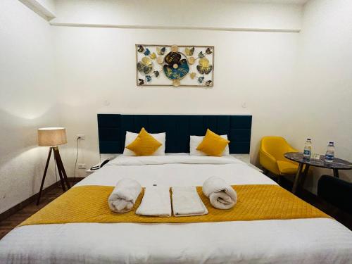 a bedroom with a bed with towels on it at Amahi Inn I Signature Towers in Gurgaon