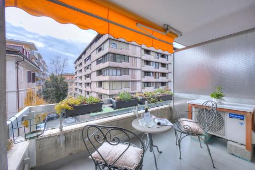 a balcony with a table and chairs and a building at Casa Astrid Werner - Happy Rentals in Viganello