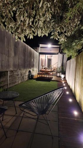um pátio com um banco e uma mesa com luzes em Paddington House em Sydney