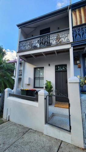 a white house with a fence in front of it at Paddington House in Sydney