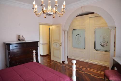 a bedroom with a bed and a chandelier at Victoria House in Mascalucia