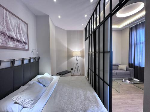 a bedroom with a large bed and a couch at Step apartment in Belgrade