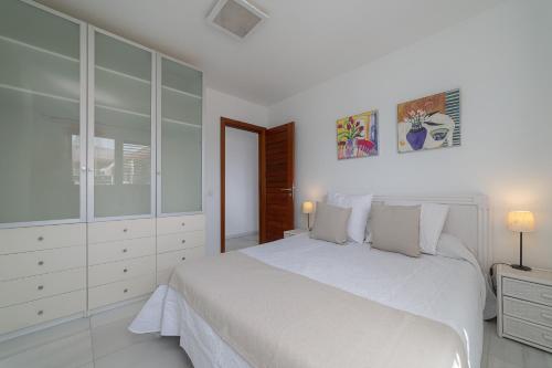 プラヤ・ブランカにあるApartamento 1 linea centro Playa Blancaの白いベッドルーム(大きな白いベッド1台、キャビネット付)