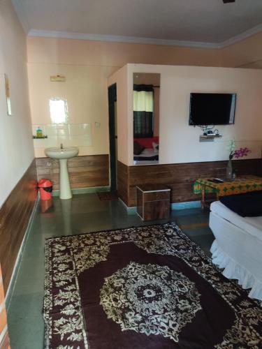 a living room with a couch and a tv on the wall at Visava Cottages Kihim Beach in Kīhīm